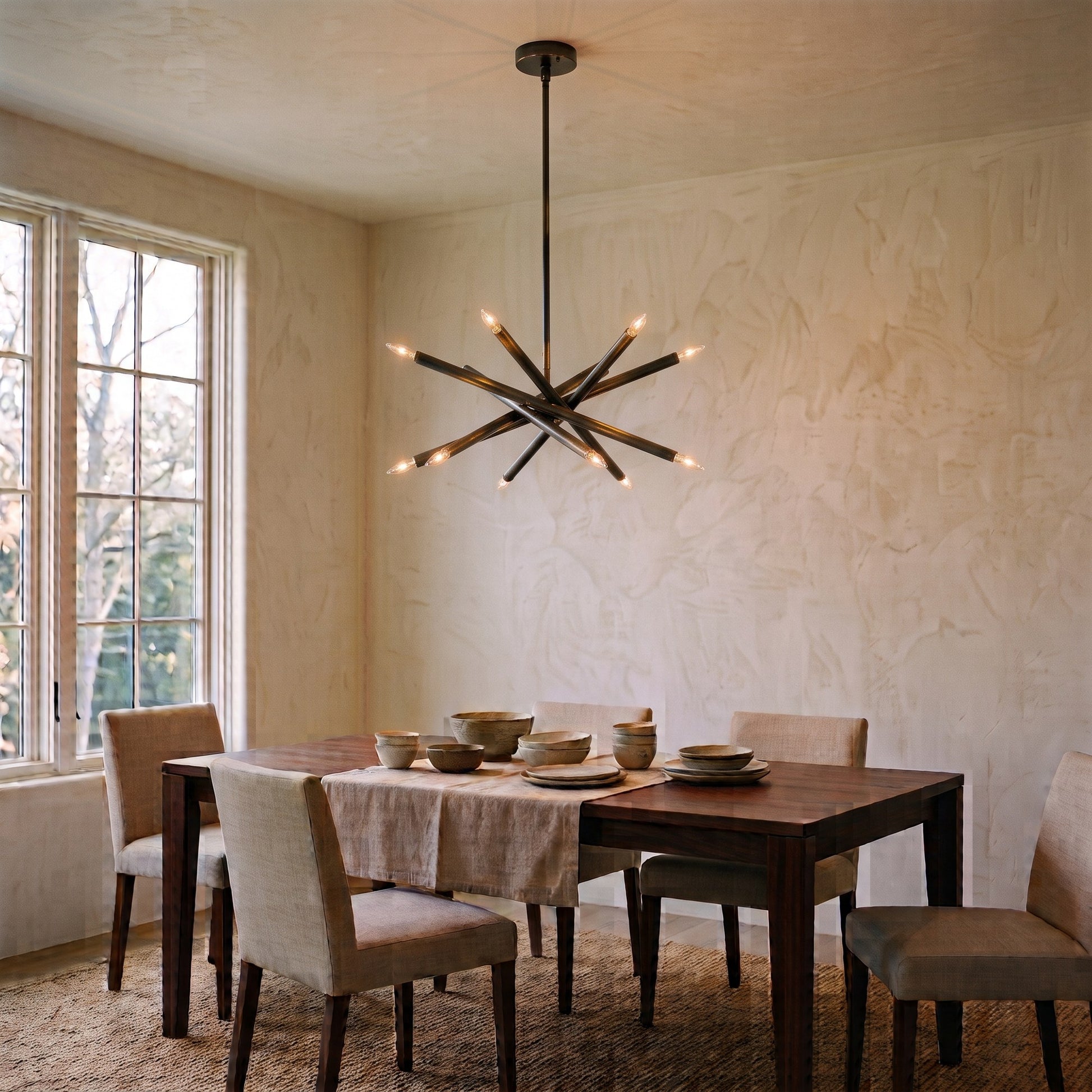 12-Light Stilnovo Chandelier – Handmade Raw Brass Ceiling Lamp in Blackened Brass, shown installed in a dining room