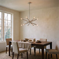 12-Light Stilnovo Chandelier – Handmade Raw Brass Ceiling Lamp in Brushed Chrome, shown installed in a dining room