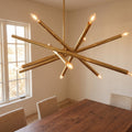12-Light Stilnovo Chandelier – Handmade Raw Brass Ceiling Lamp in a room