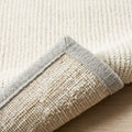 Neutral Toned Area Rug, folded corner showing the back
